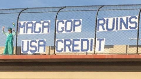 Indivisible ABQ held banners over a highway overpass near downtown Albuquerque – getting many honks and waves!